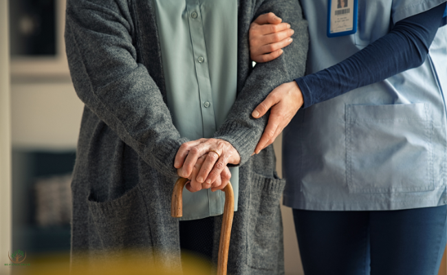 A caregiver steadying a client's hand on a cane